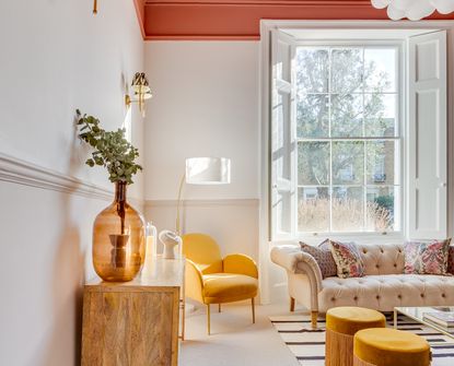 A living room with white walls, beige wainscoting, and a terracotta ceiling