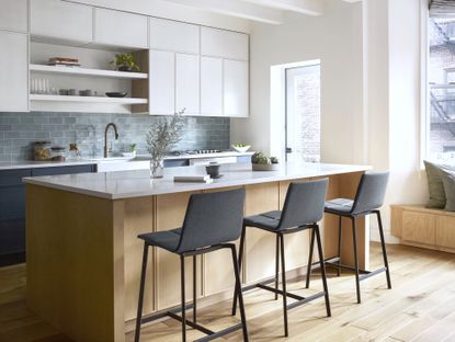 A white kitchen with pale blue colored tiling